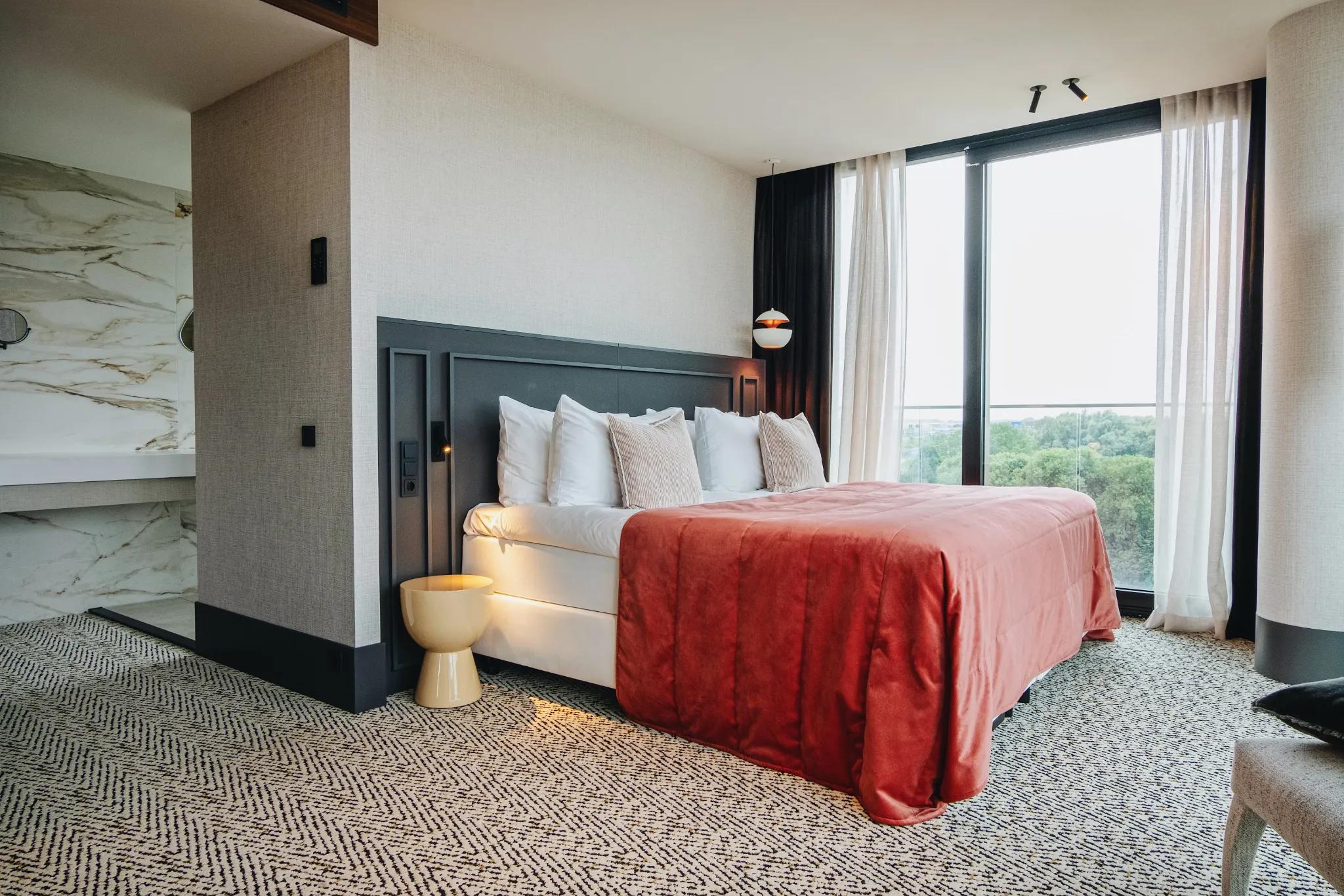 Suite in het Van der Valk Hotel in Best; dit is het grote bed met een rode deken eroverheen